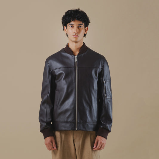 Man wearing a brown leather jacket against a beige background