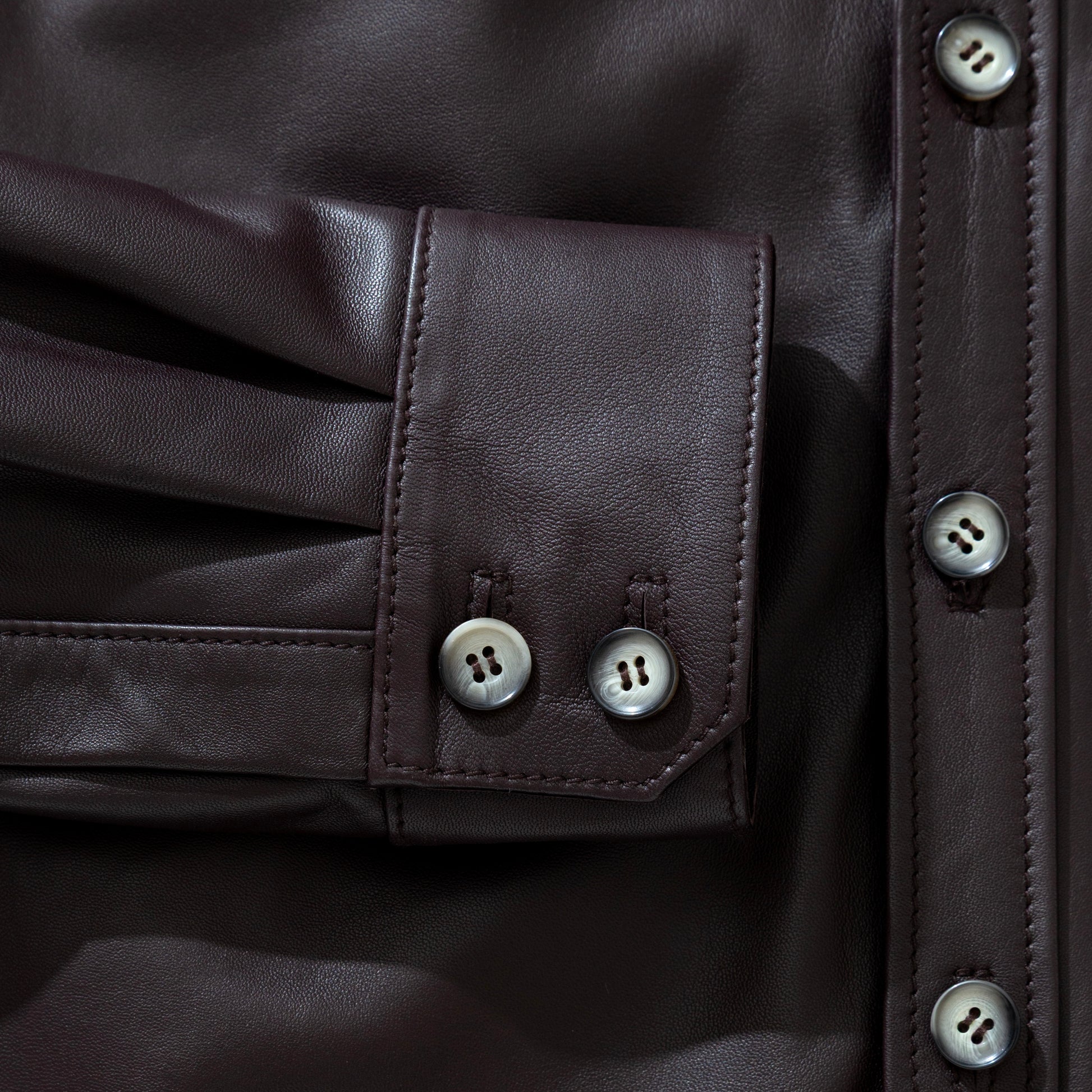 Close-up of a dark shirt leather jacket with button details