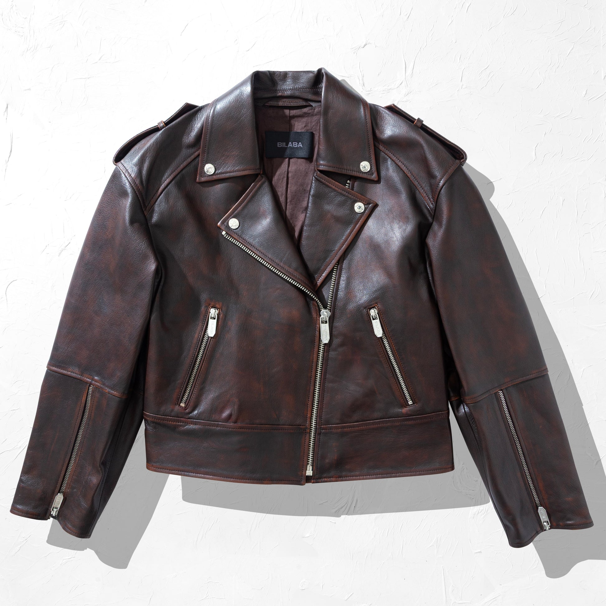Brown vintage leather biker jacket on a white background