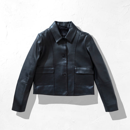Black collared button leather jacket on a textured white background