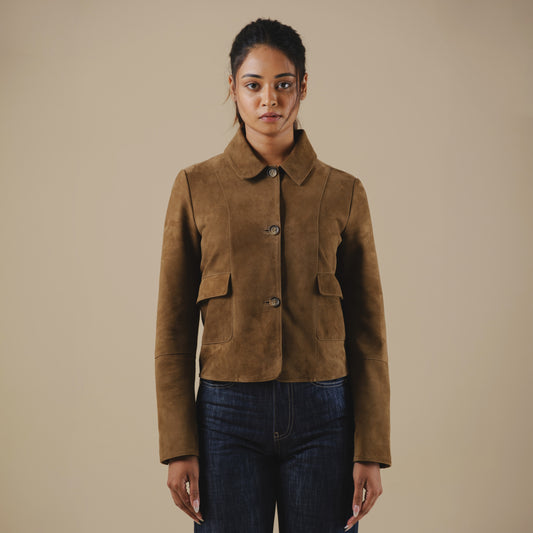 Woman wearing a brown suede jacket against a beige background