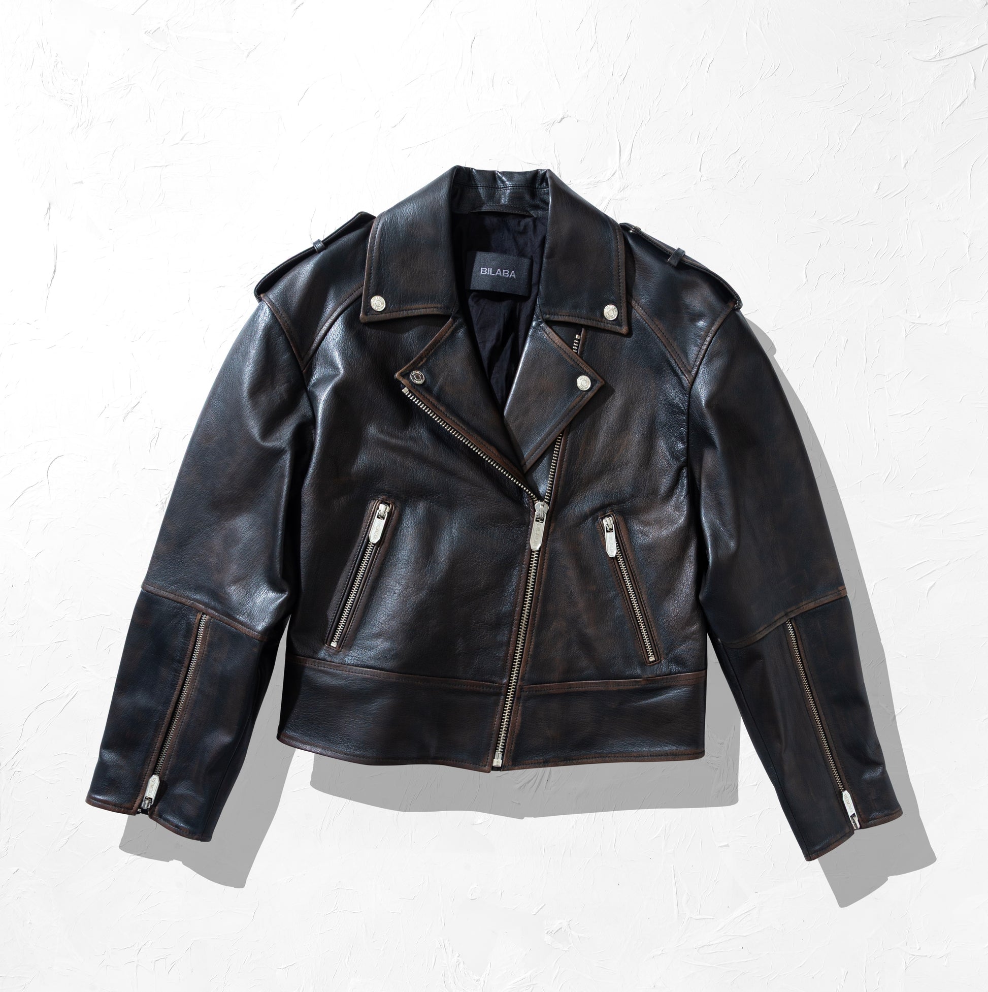 Black vintage leather biker jacket with zippers on a white background
