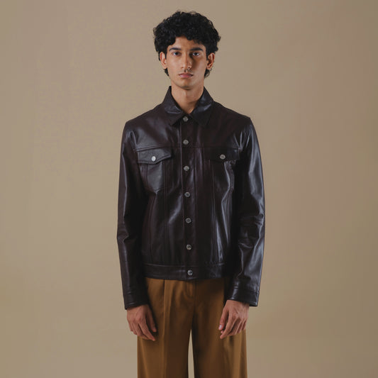 Man wearing a dark brown tucker leather jacket against a beige background