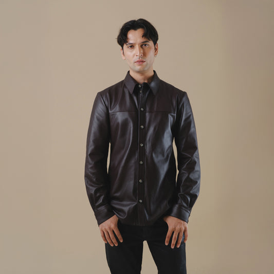 Man wearing a dark brown leather shirt against a beige background