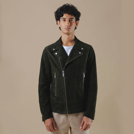 Man wearing a forest green leather jacket against a beige background