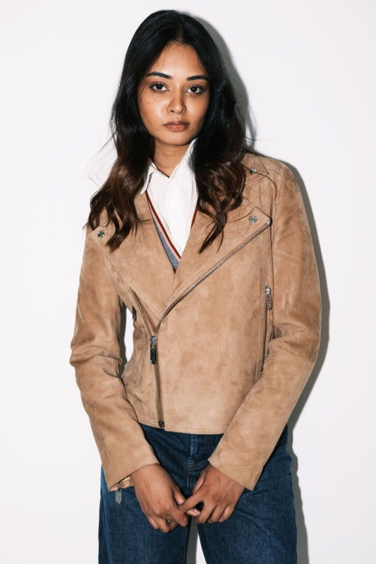 Woman wearing a beige suede jacket against a white background